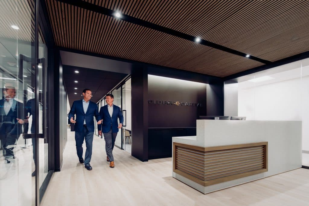 A view of the entrance area to Cold Bore Capital HQ with Sergio and Matt walking down the hallway.